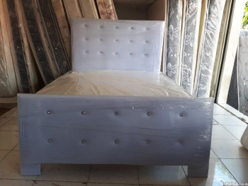 Cama tapizada blanca con colchón