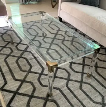 Mesa de centro en acrílico con detalles de metal dorado